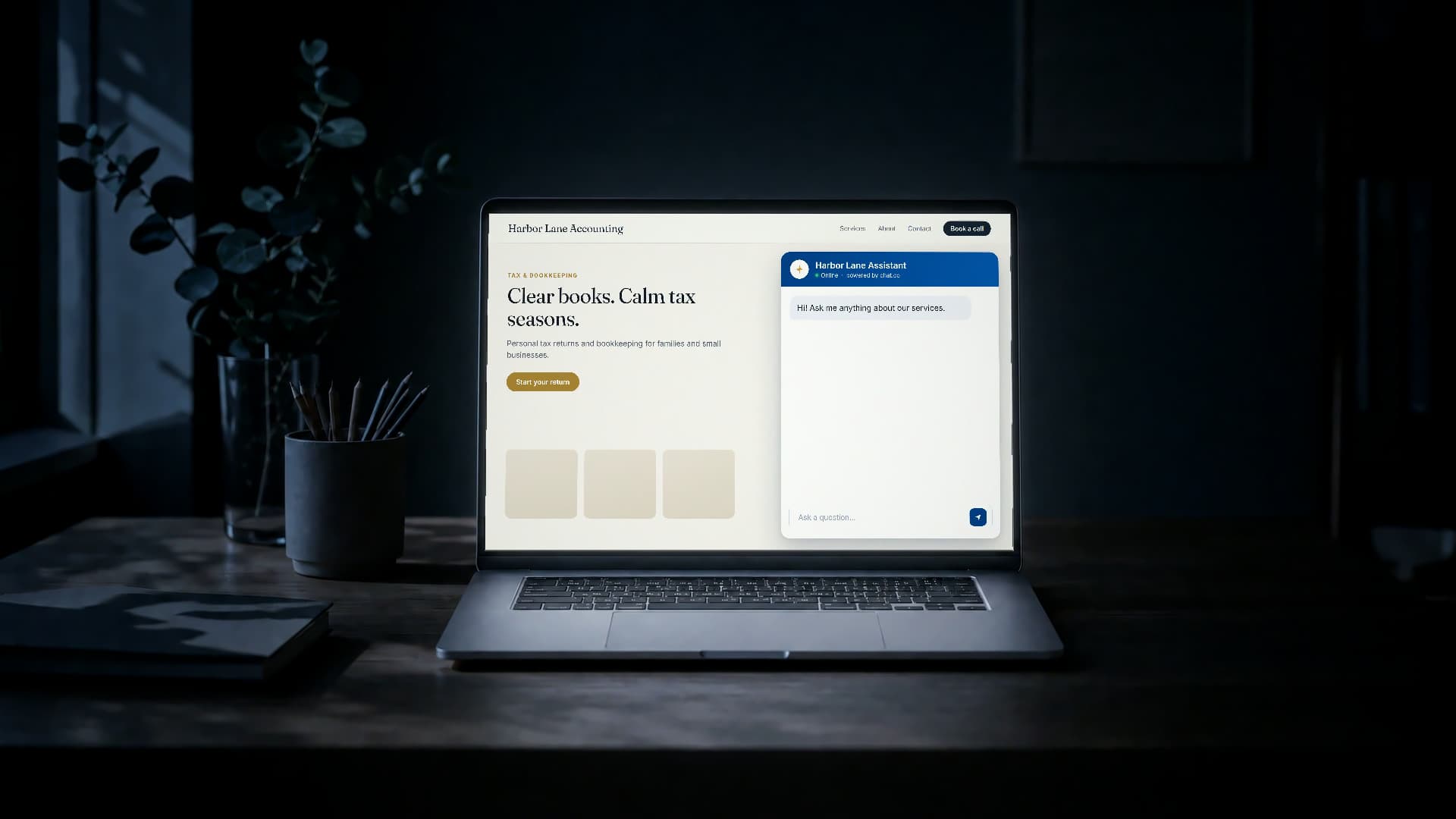 A laptop on an empty desk in a dark office, a chat.co conversation open on the screen